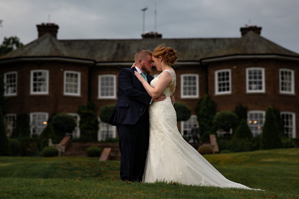 Couple embrace in front of stately home