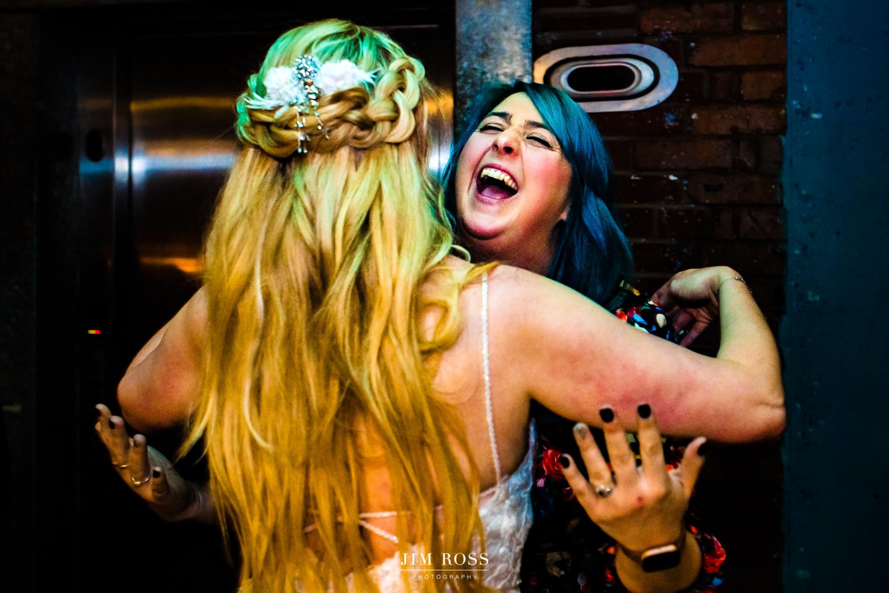 blue haired guest elated to hug bride