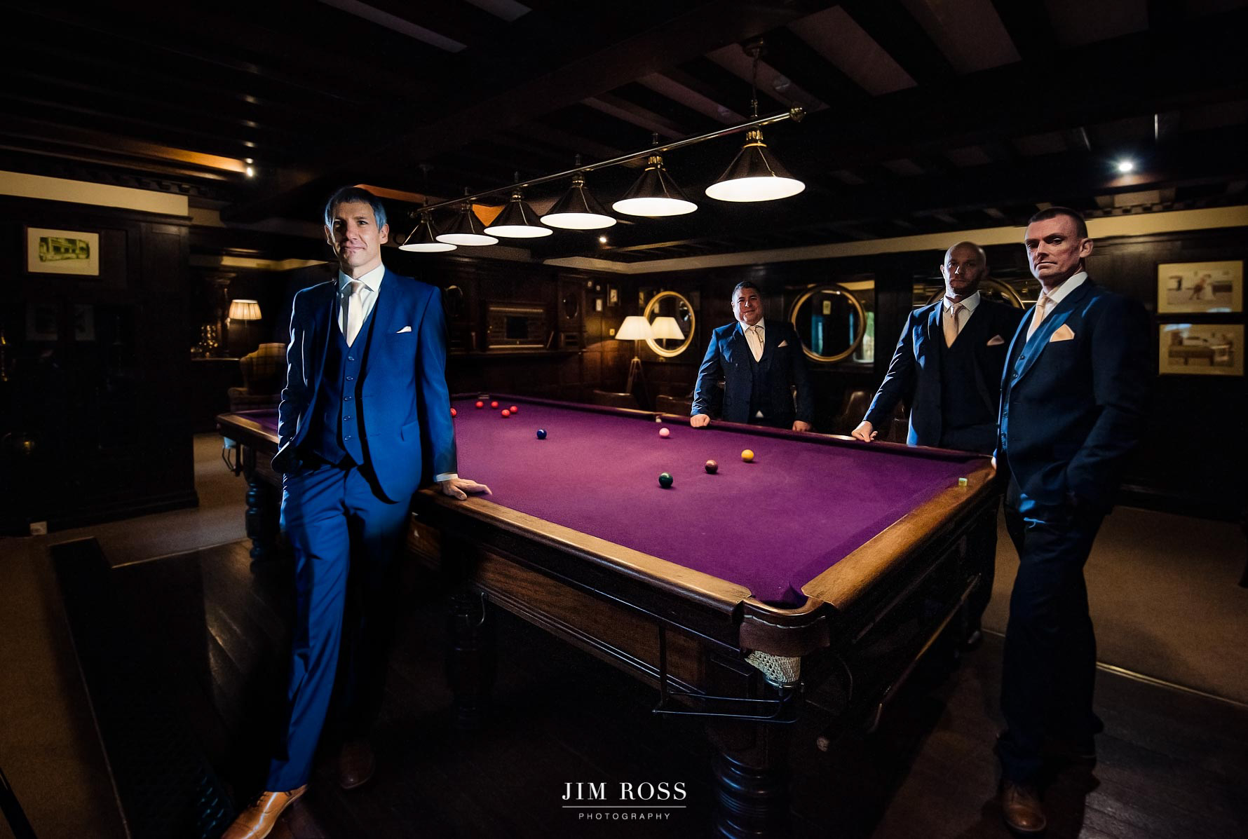 groomsmen posing around pool table