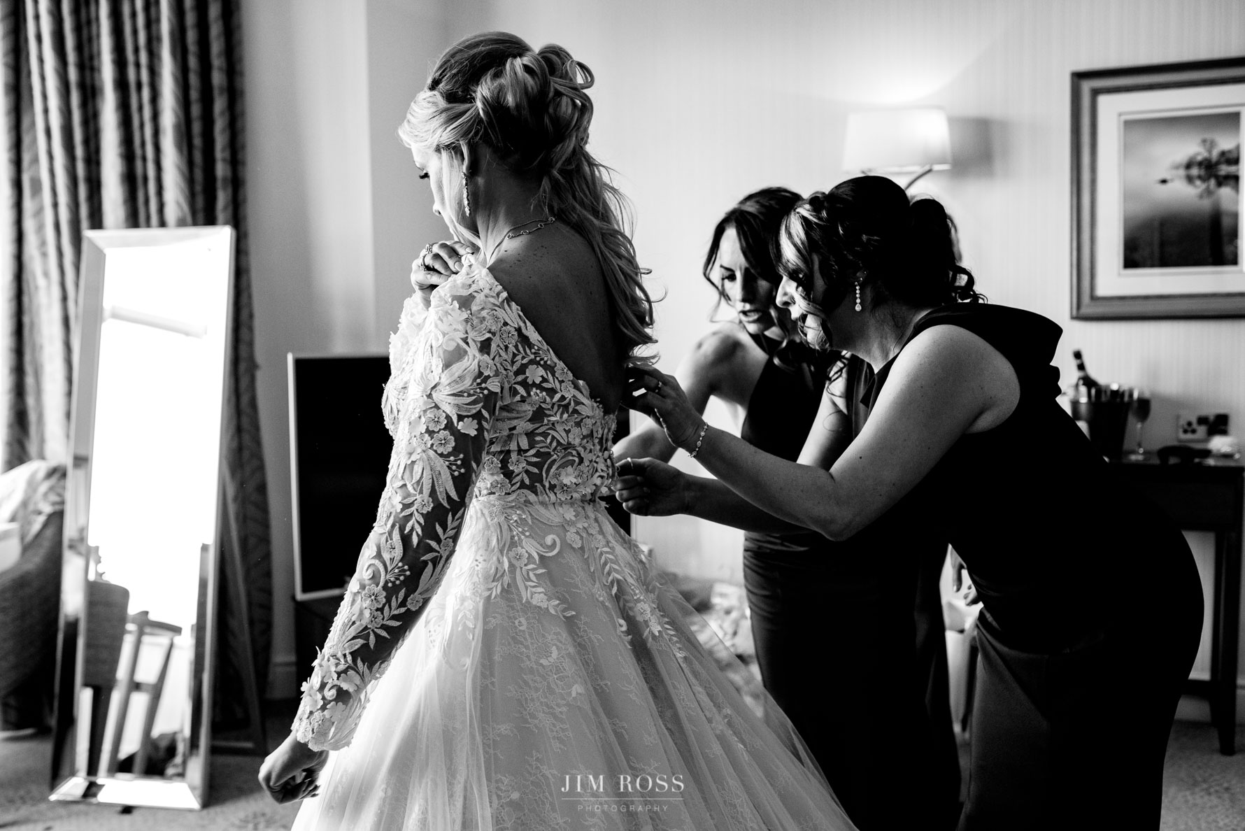 bridesmaids adjust bride's dress