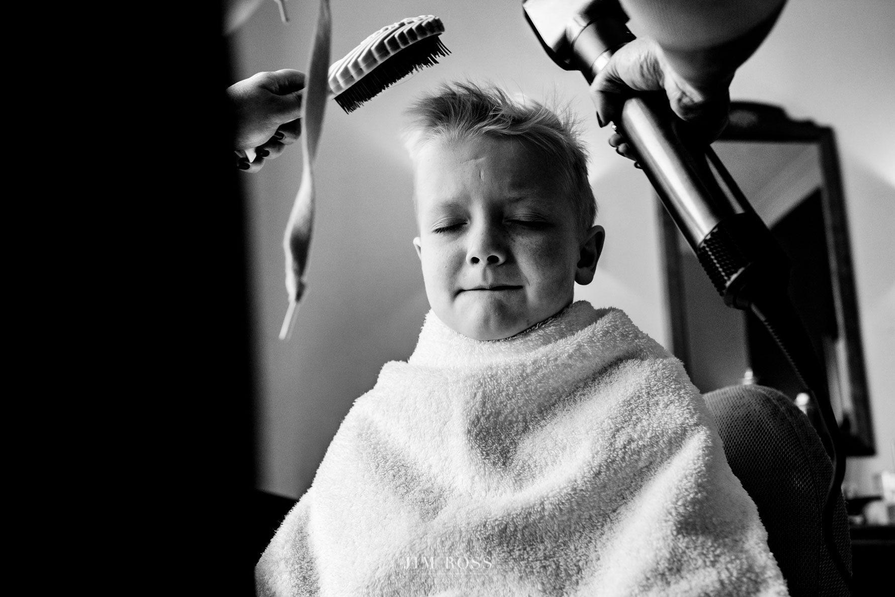 page boy grimacing at hairdryer treatment