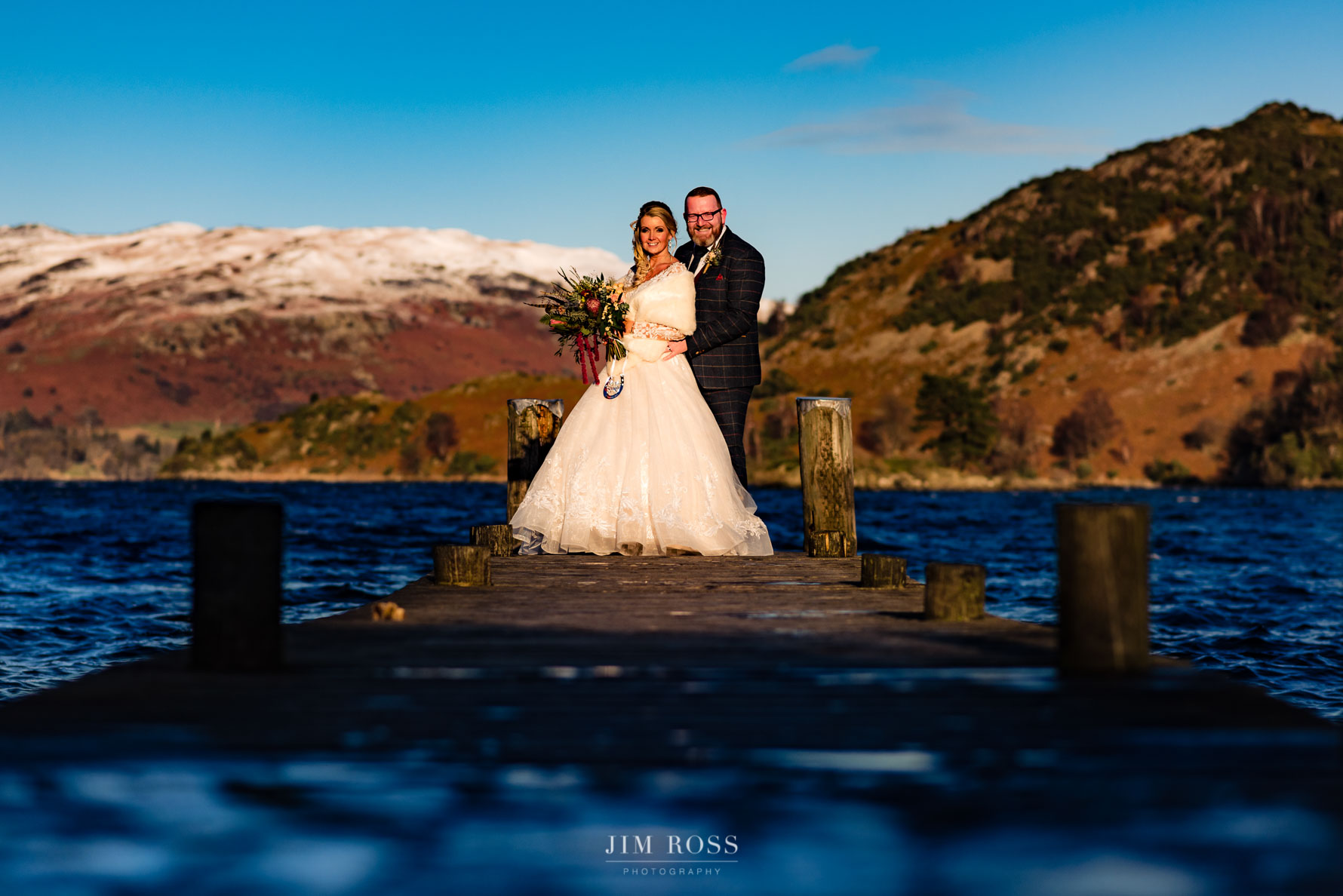 couple on jetty at winter wedding ullswater