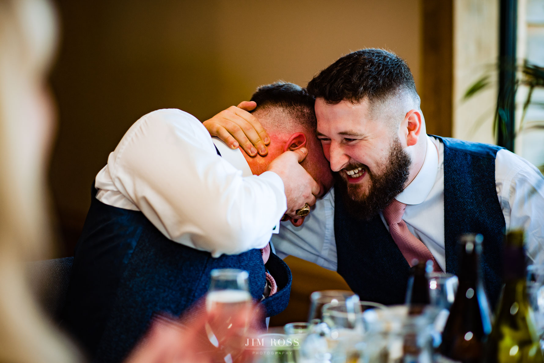 best man lends shoulder to cry on to brother of groom