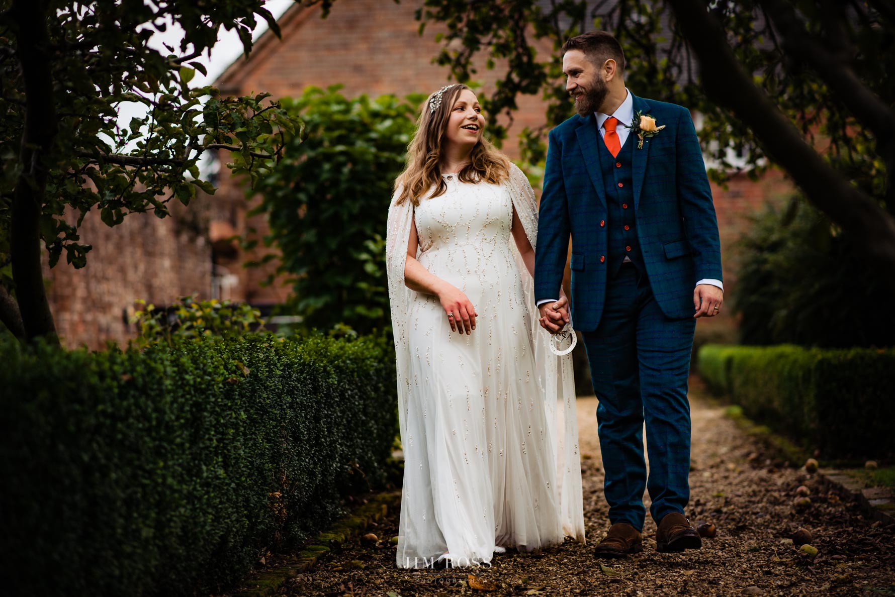 newlyweds walking through walled garden