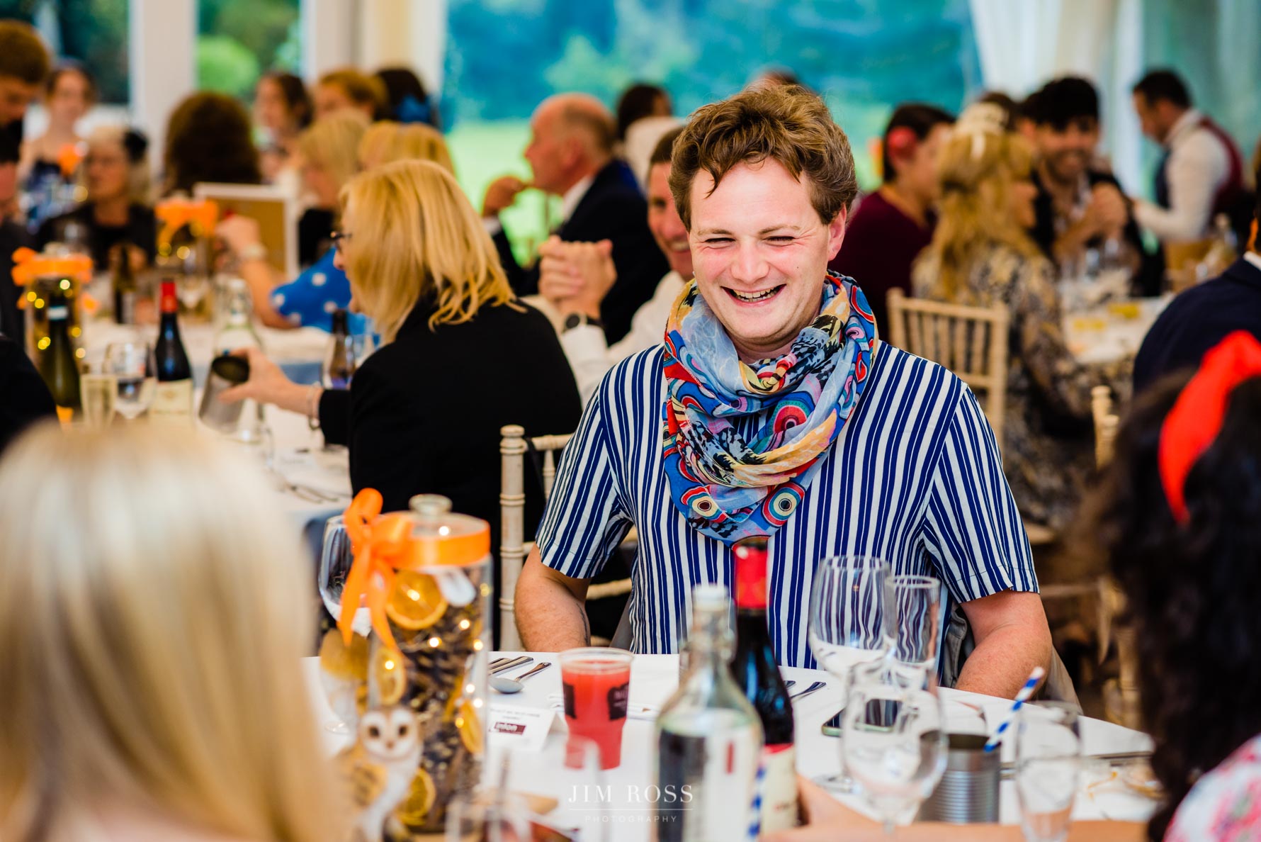 colourful wedding guest at table having a laugh