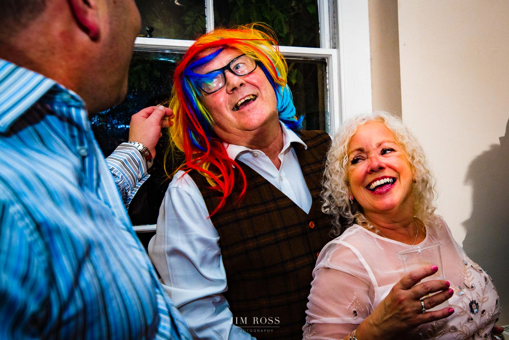 parents of groom laughing in funny wig