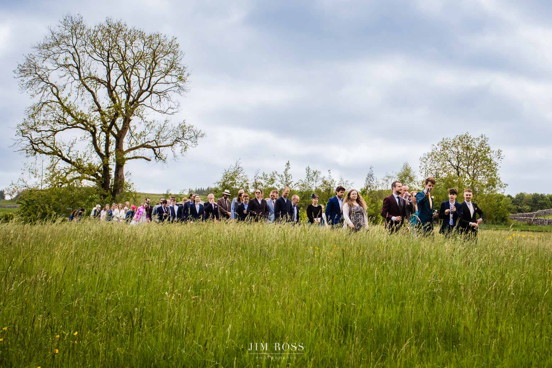 wedding guests file out of ceremony field