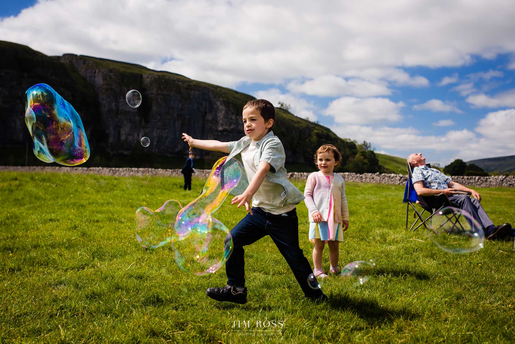 kids bloowing giant bubbles at wedding