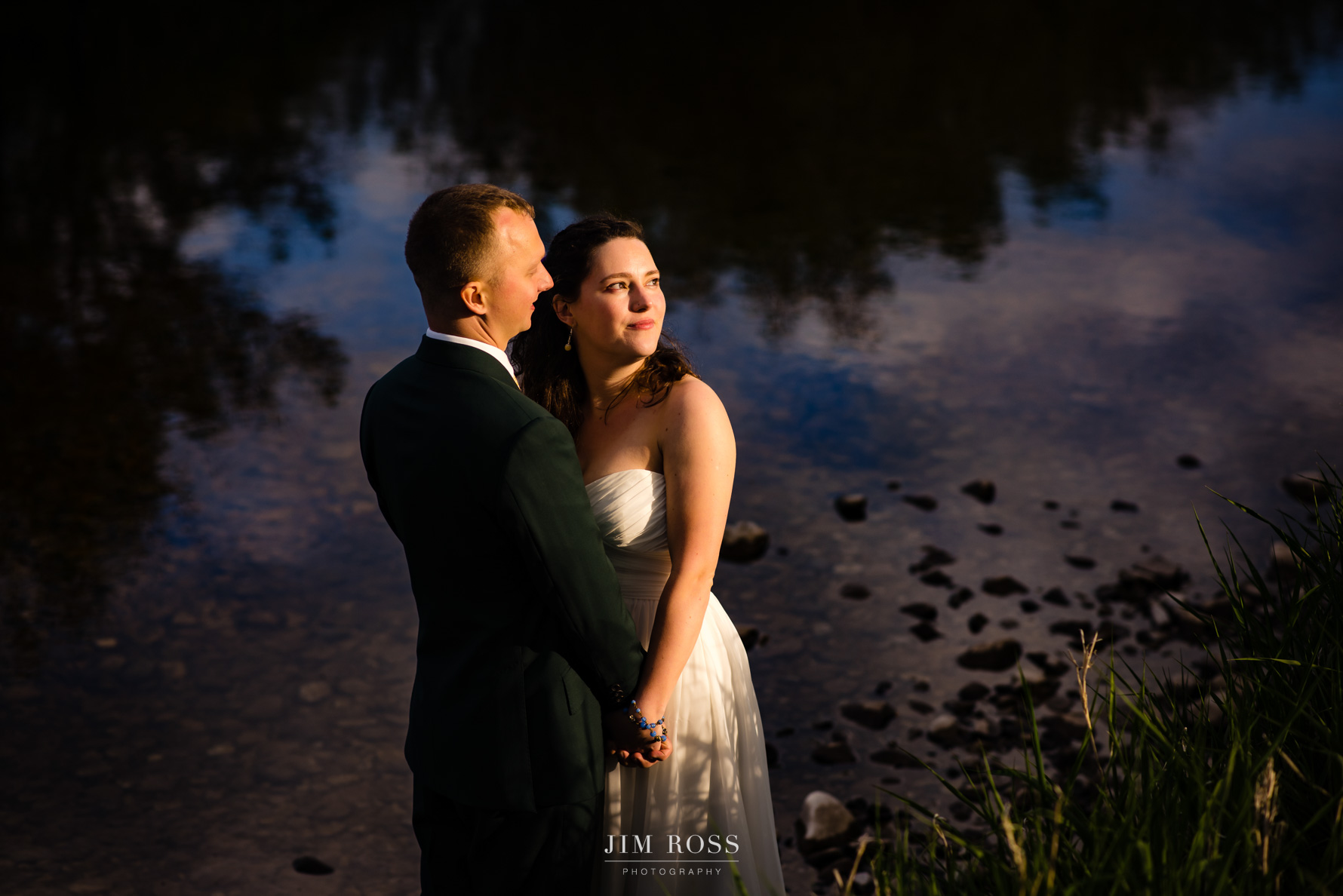 wedding portrait by river - looking into setting sun