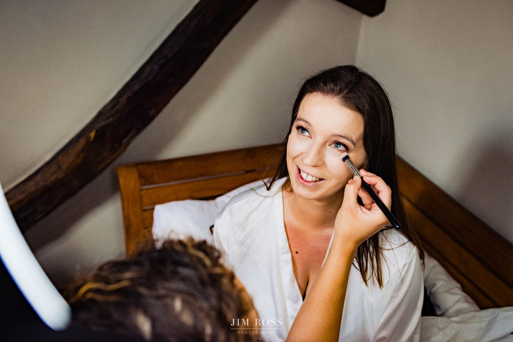makeup applied to smiling bride