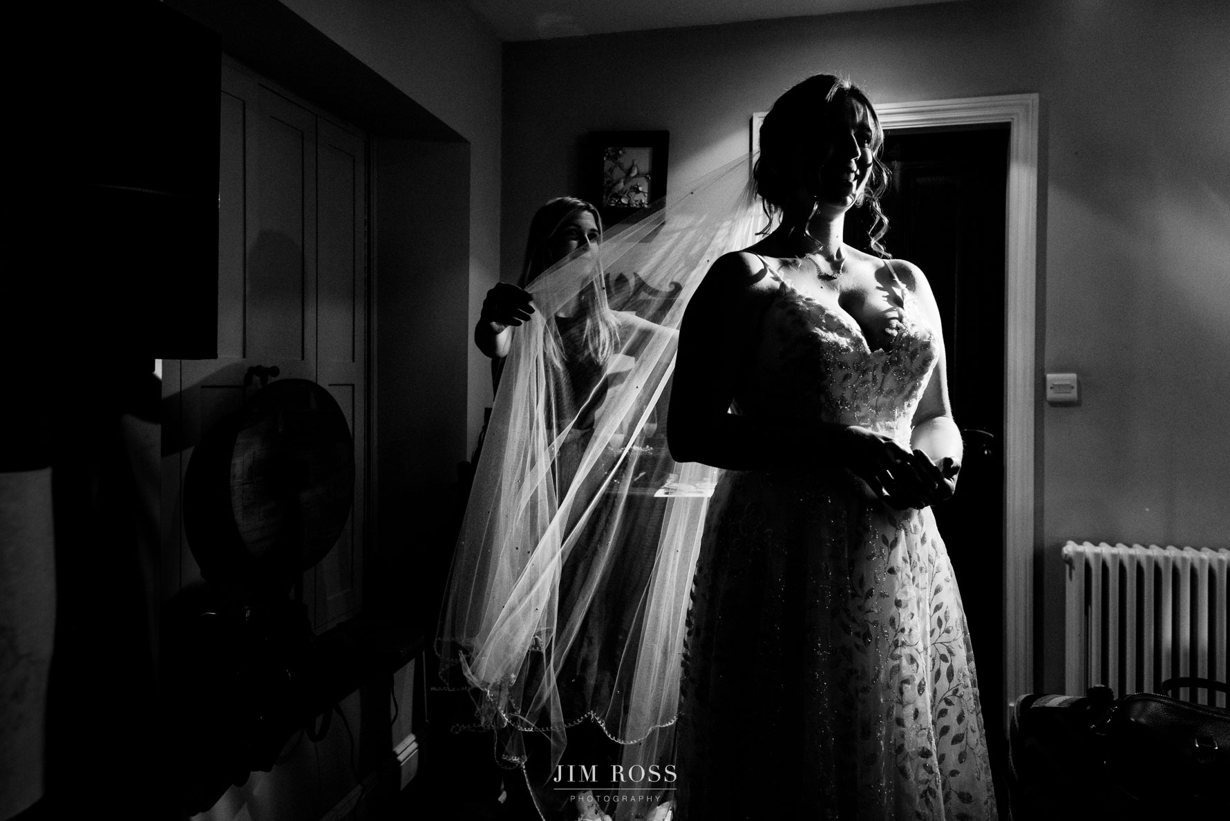 dramatic shot of bride with veil being adjusted