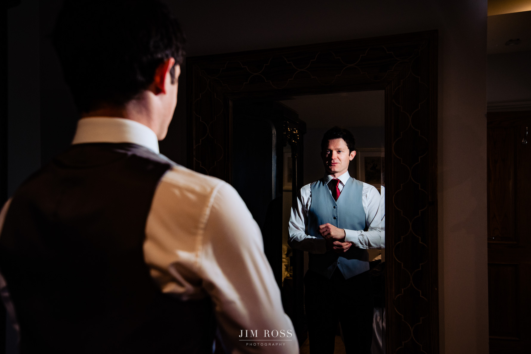 groom checks cufflinks in mirror