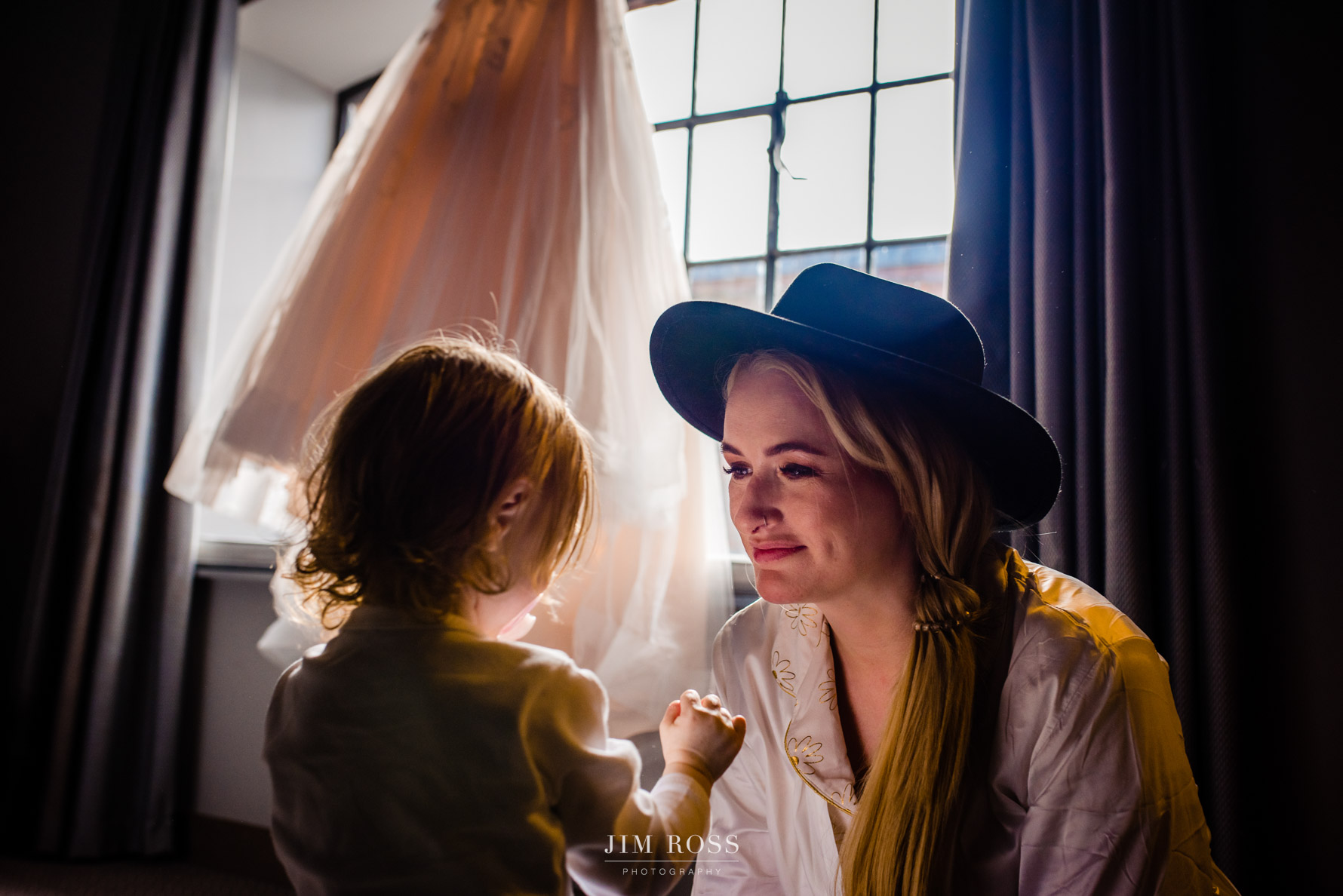 bride with hat and daughter. dress in background