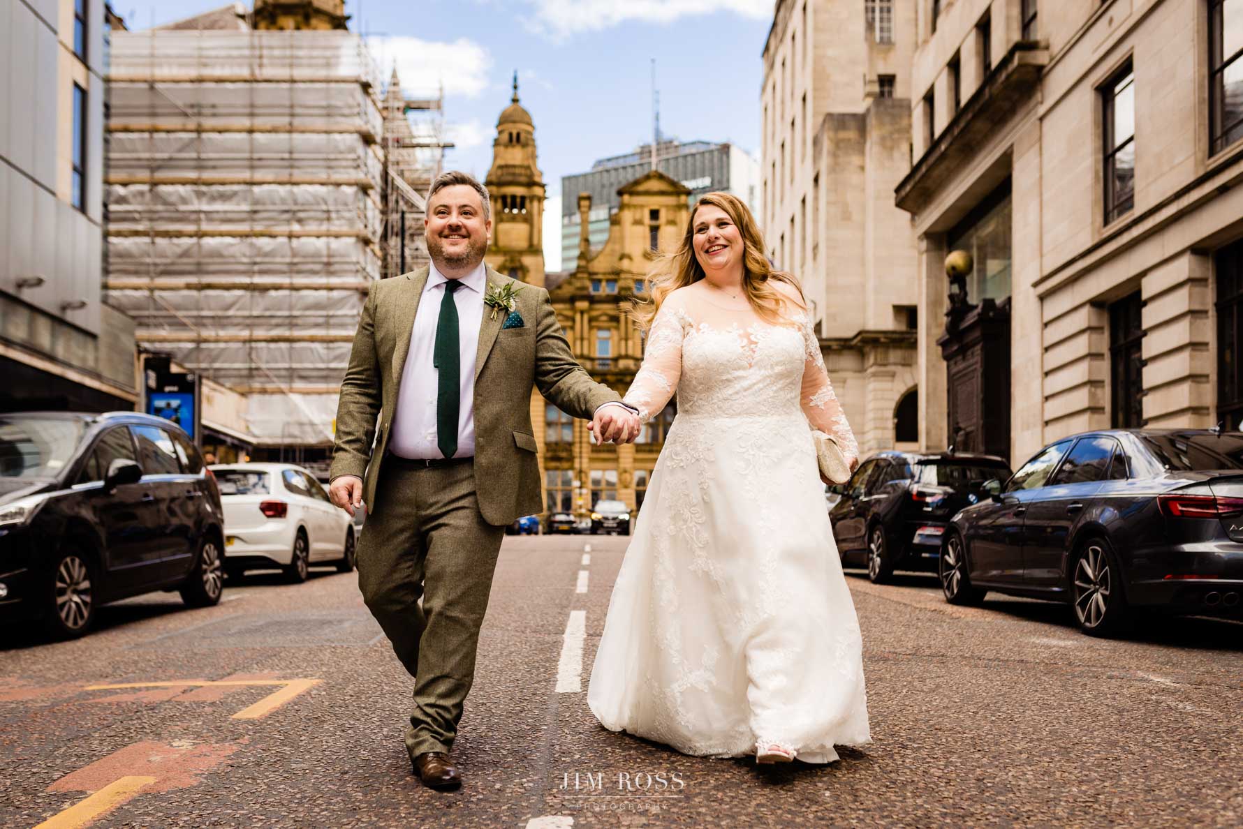 Happy couple striding down King Street Manchester